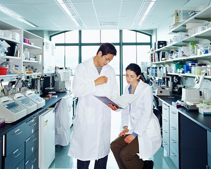 Selon Getty Image : "Research scientists looking at paperwork on clipboard"
