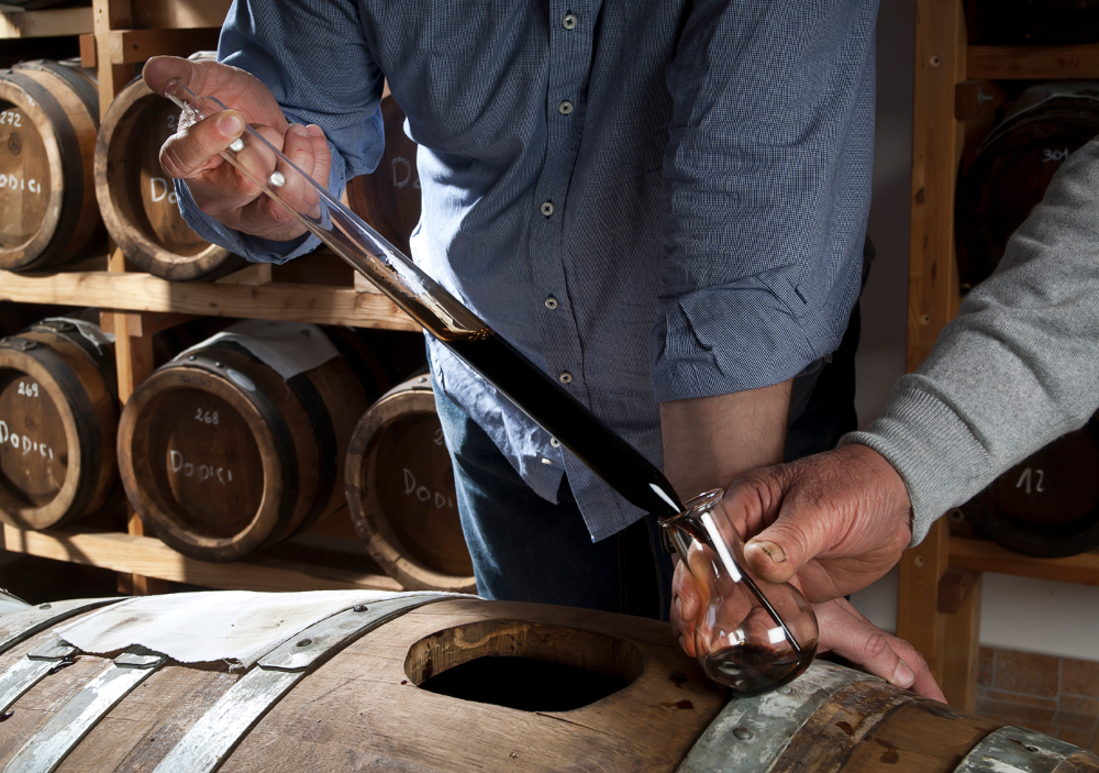 A person pouring vinegar into a container with a pipette