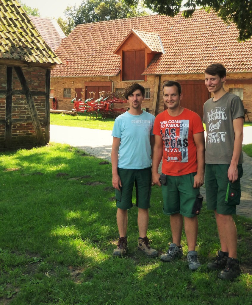 3 farmers in front of a house