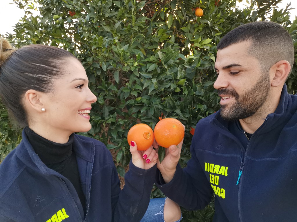 Ana and Sergio Mu&ntilde;oz with freshly picked oranges in their hands